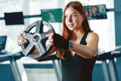 Smiling teen girl training in a fitness club