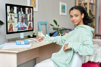 Teen african girl school student learn online class at home looking at camera.